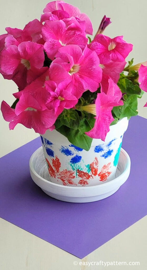 A painted clay pot with petunia flower.