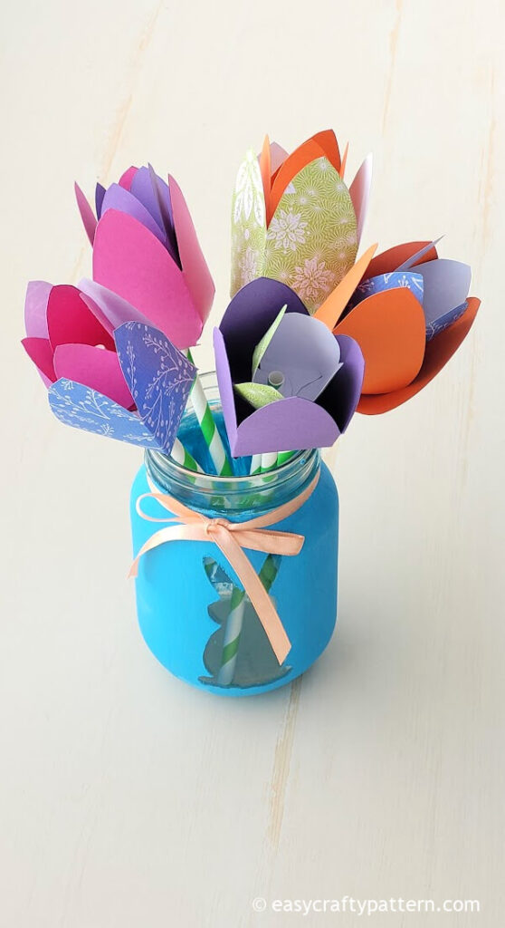 Colorful paper tulips on blue vase.