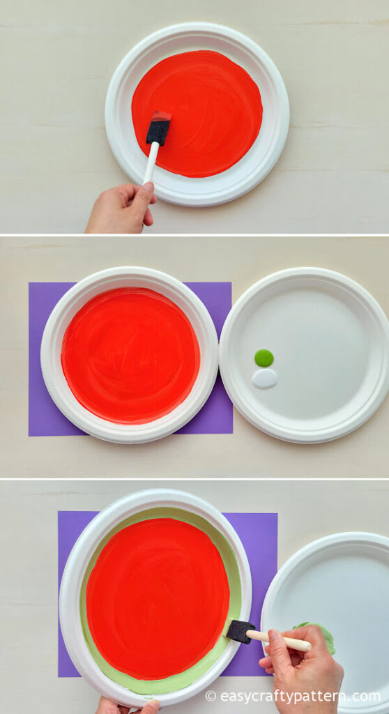 Painting red and green on paper plate.